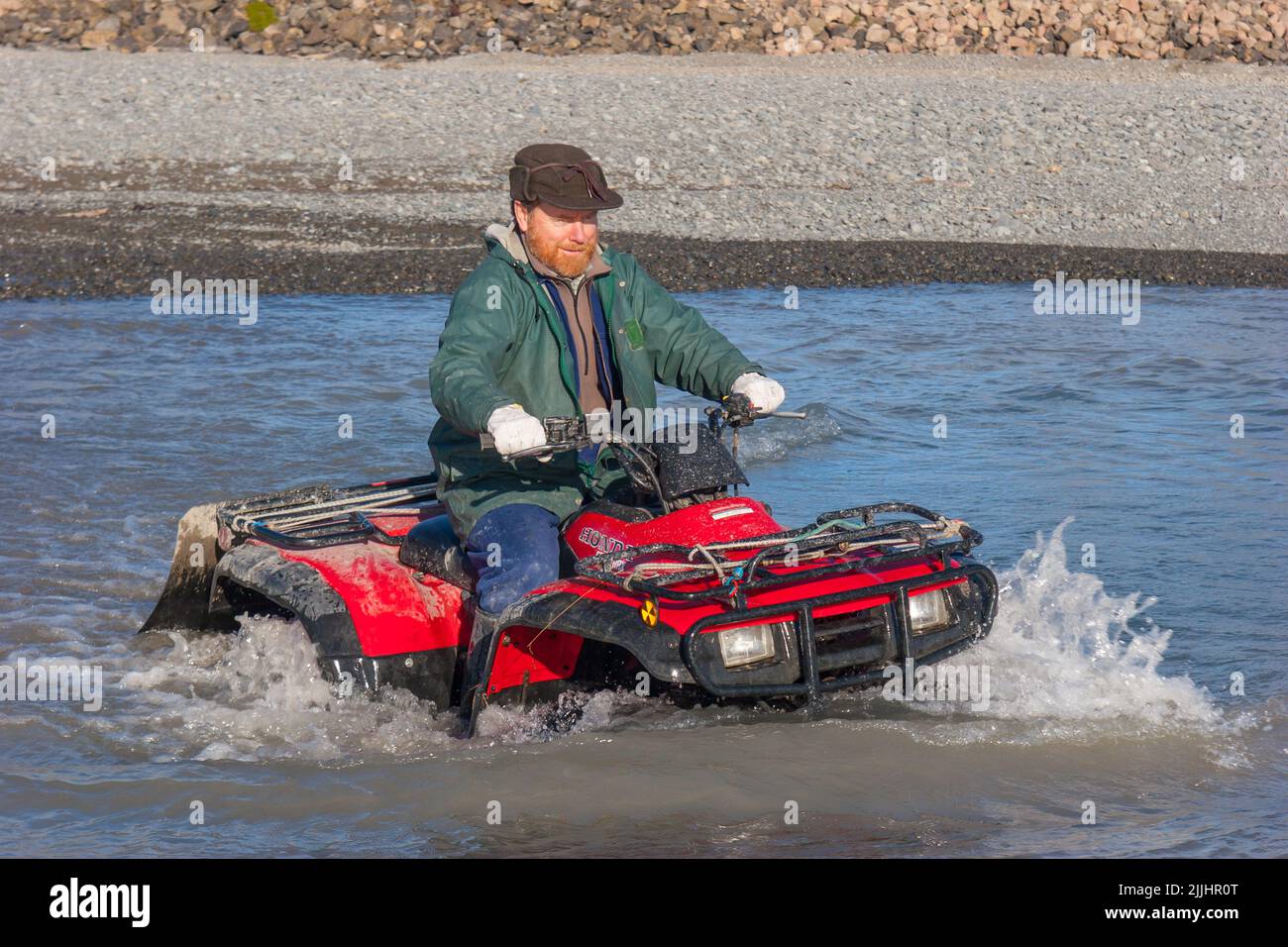 A Look at life in New Zealand: practising river crossings and mud bogging on the Quadbike: often the only way to reach the best fishing spots. Stock Photo