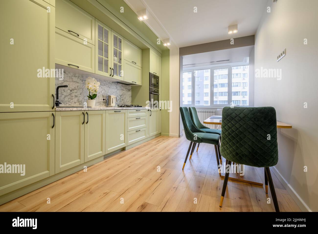 Modern light green luxurious kitchen with dining table Stock Photo - Alamy