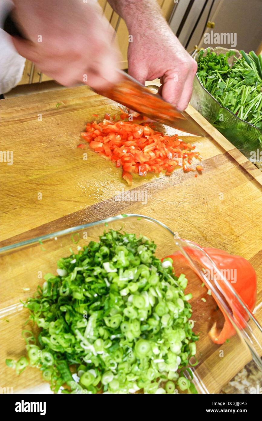 Florida Kendall,Hispanic Latin Latino ethnic immigrant immigrants minority,adult man male,chef makes how to cook video,kitchen cutting red pepper Stock Photo