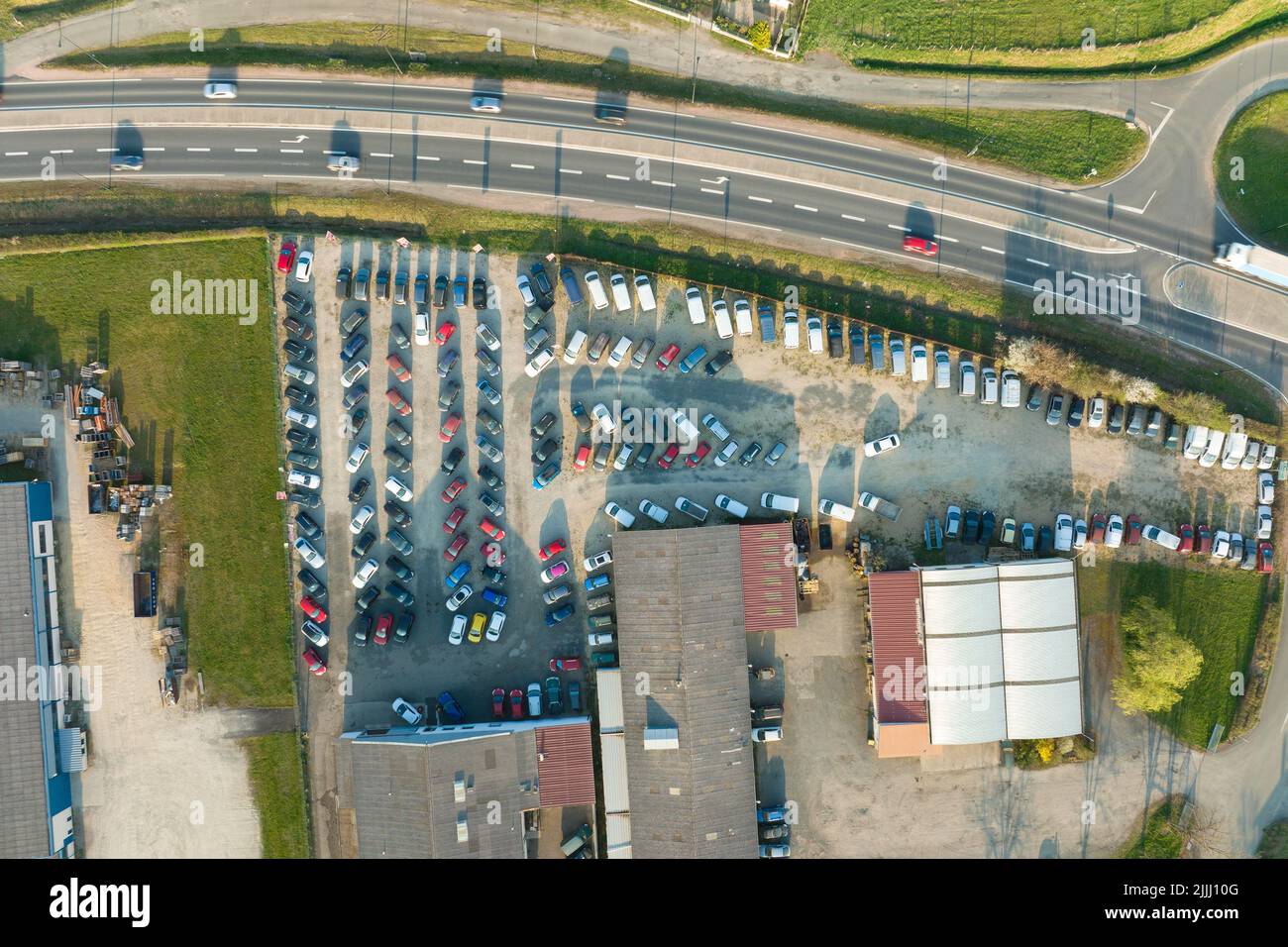 Aerial view of many colorful cars parked on dealer parking lot for sale