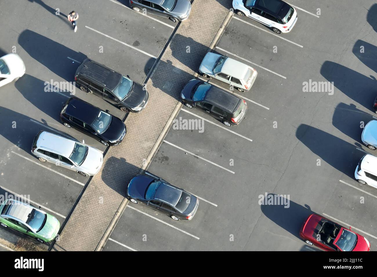 Aerial view of many colorful cars parked on parking lot with lines and