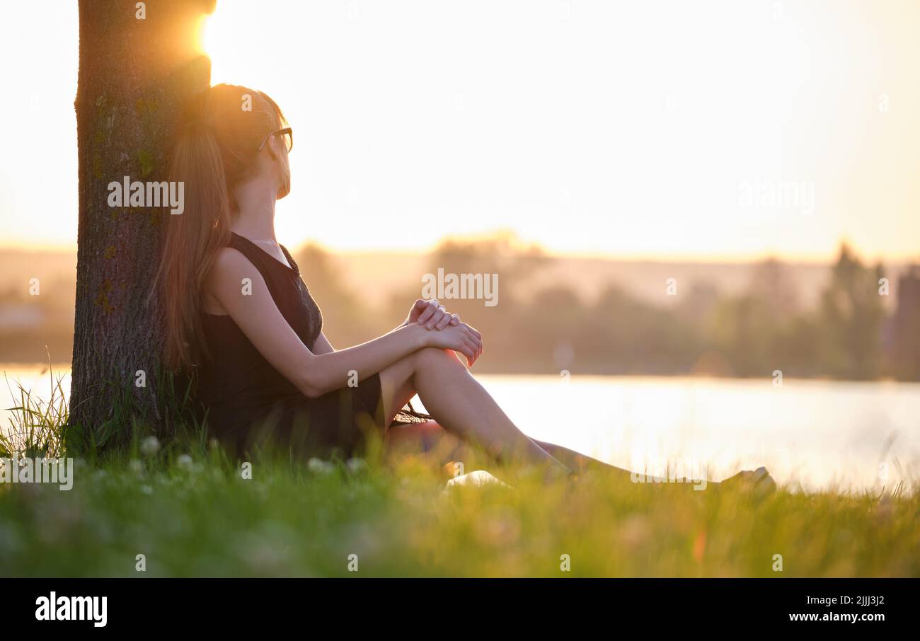 Sad girl sitting in grass hi-res stock photography and images - Alamy