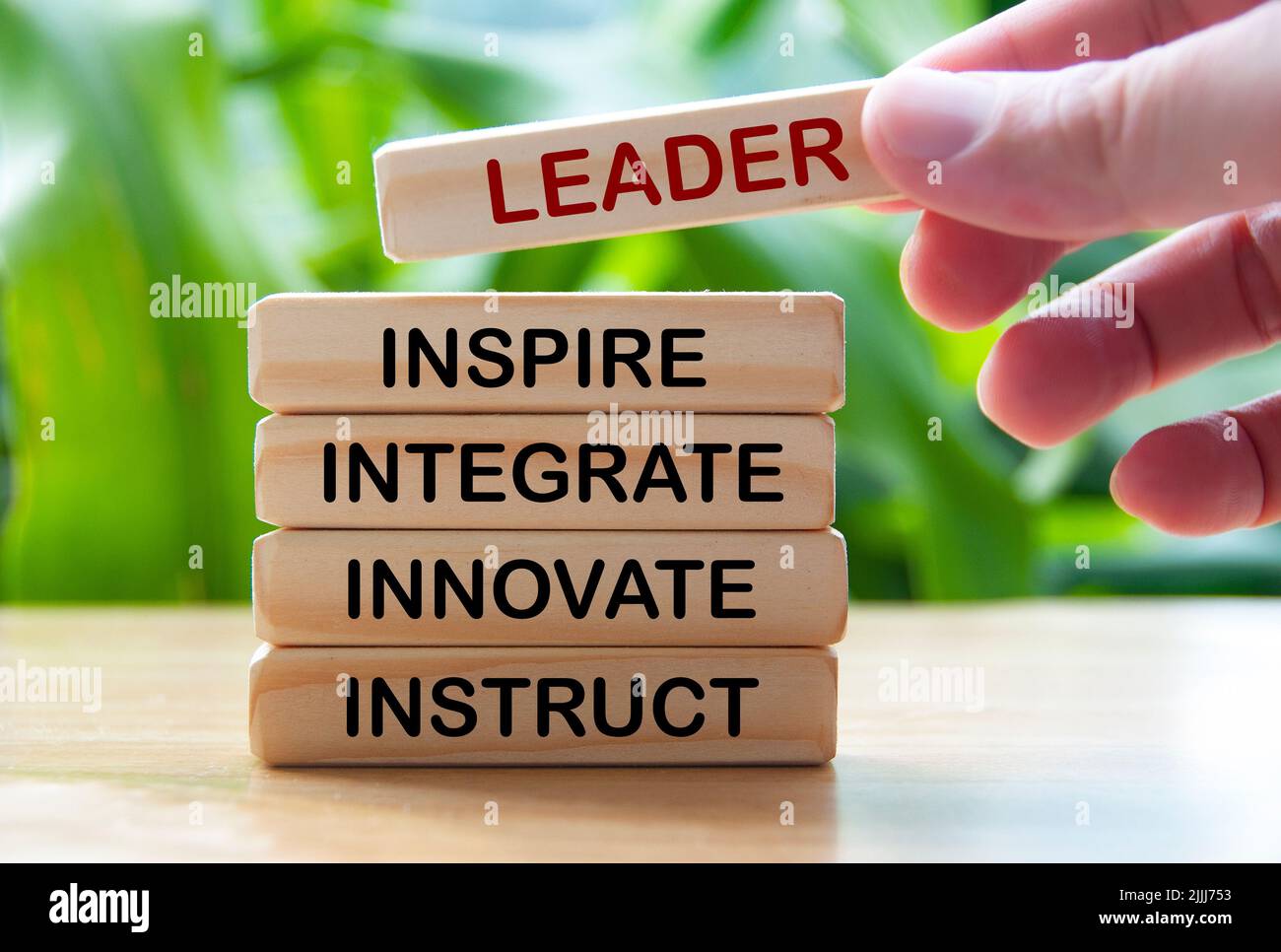 Hand holding wooden blocks with text - Leader, inspire, integrate, innovate, instruct. Leadership concept Stock Photo