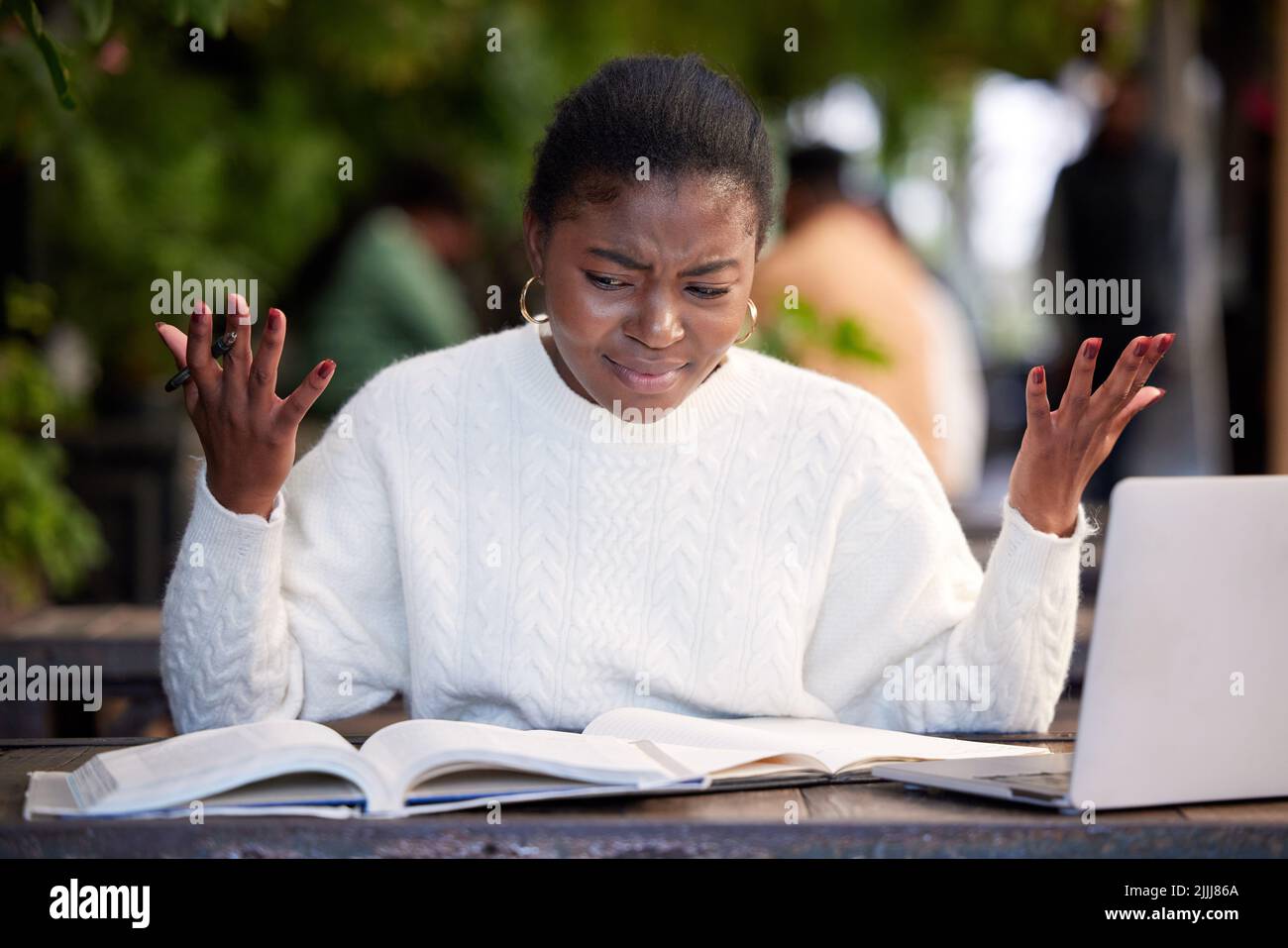 I dont understand. a young woman looking stressed while studying in a cafe. Stock Photo