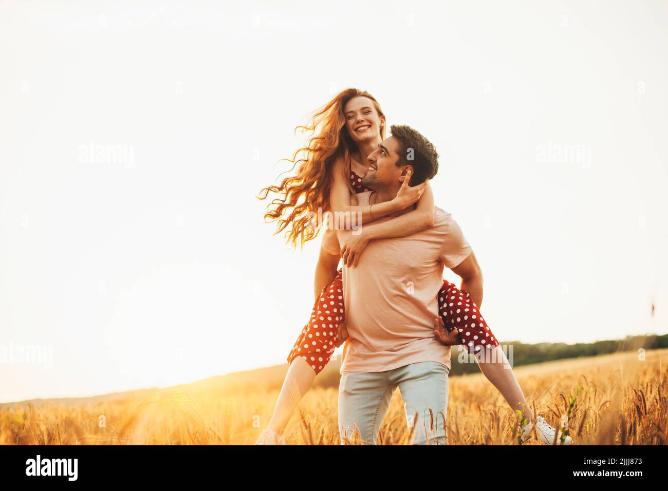 Caucasian man giving his girlfriend a piggyback as they enjoy walking