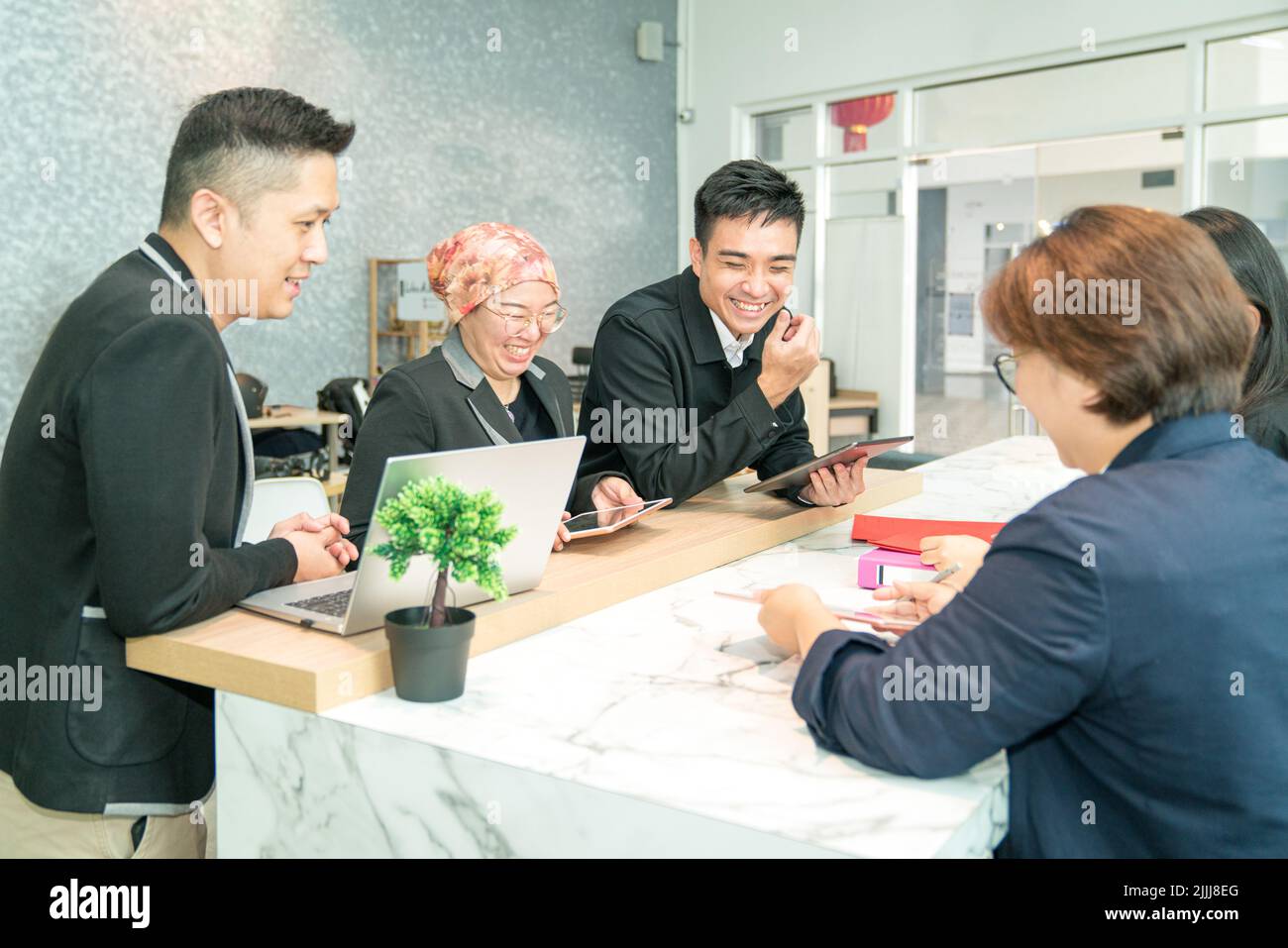 Business colleagues work team laughing while having meeting in co working space. Stock Photo
