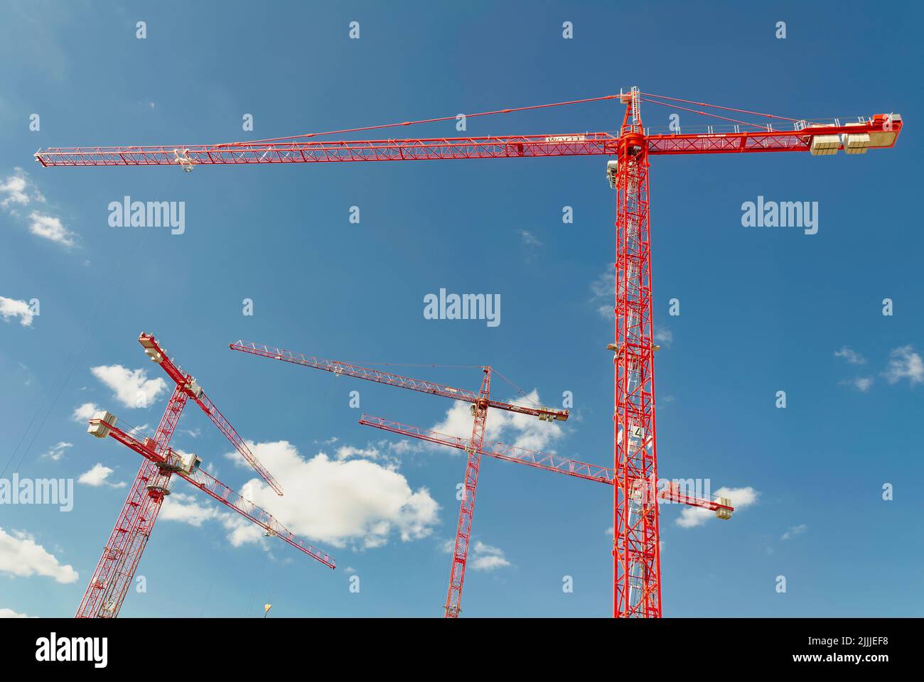A low angle shot of red cranes against blue sky Stock Photo - Alamy