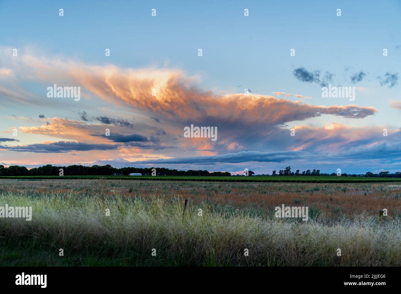 A beautiful sunset view of cloudy sky over large grass fields Stock ...