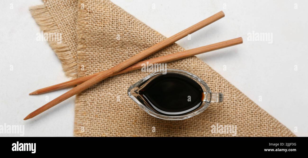 Gravy boat of soy sauce and chopsticks on white background Stock Photo Alamy