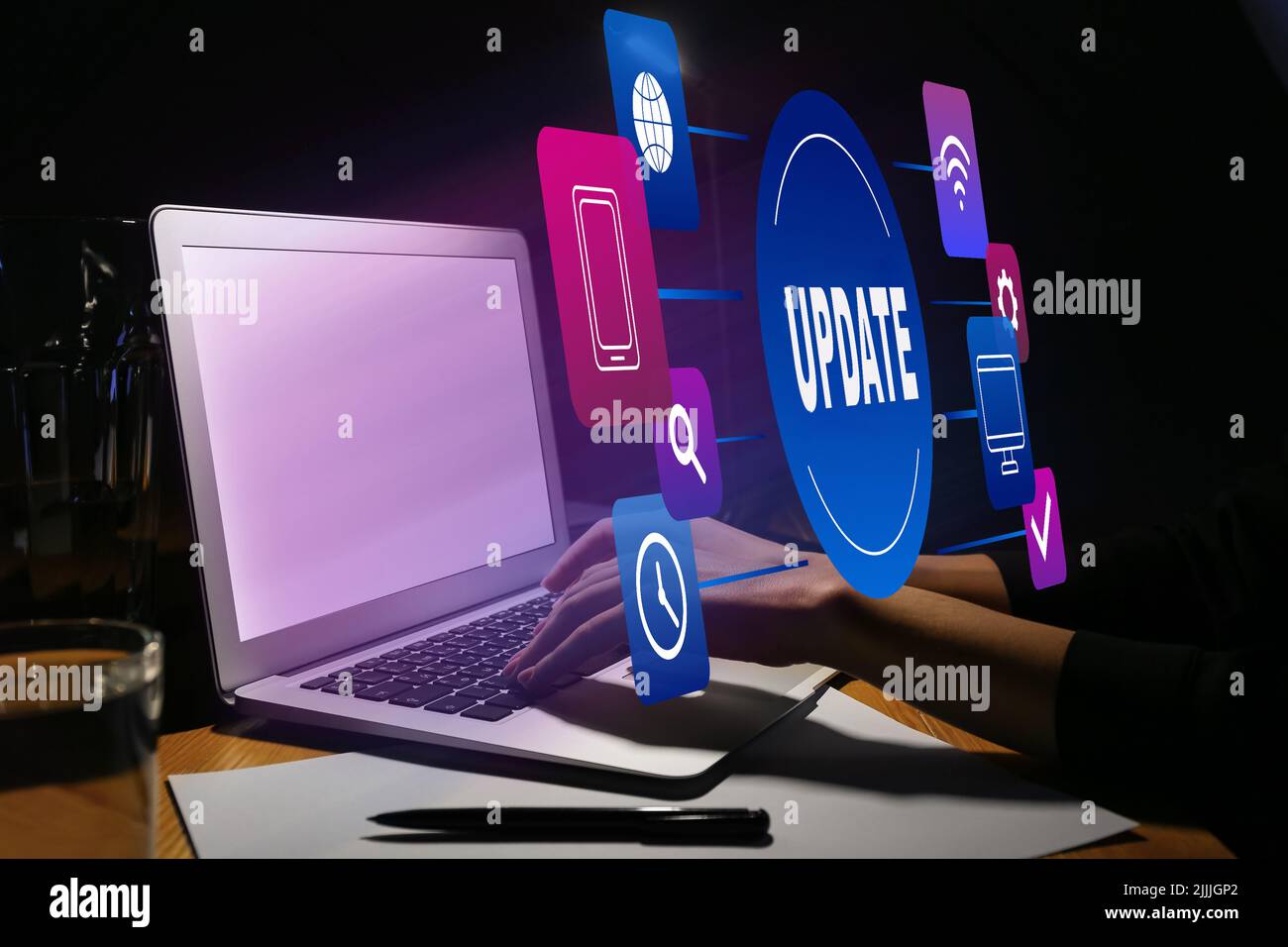 Woman working on laptop at table in evening. Concept of update Stock Photo
