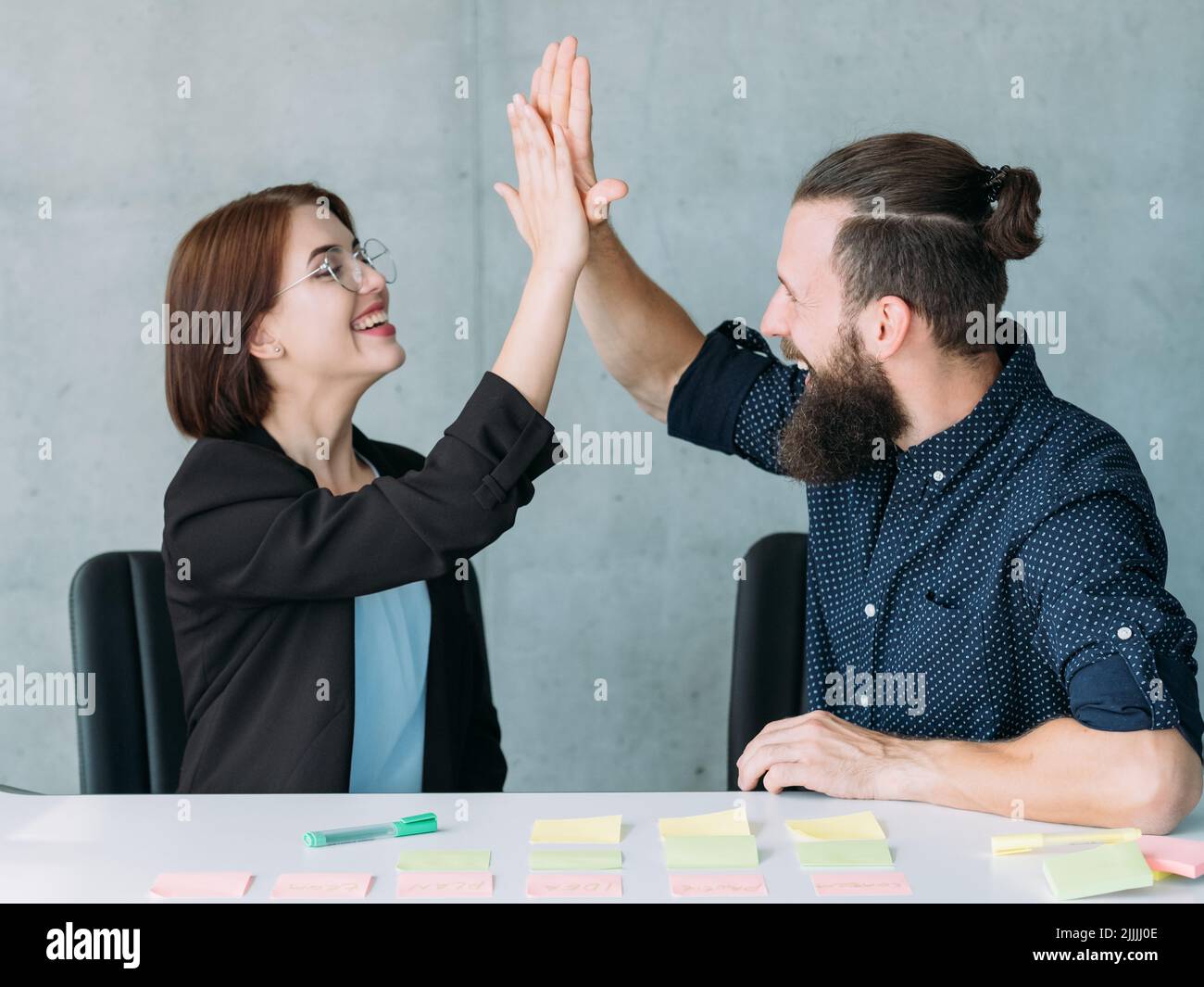 man woman high five office teamwork success Stock Photo