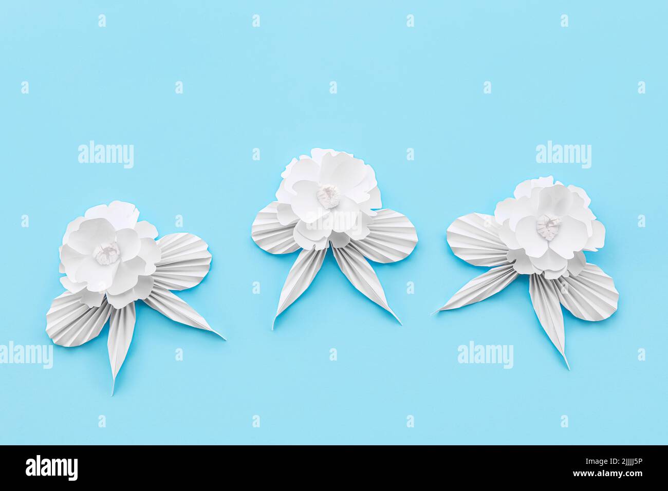 Paper flowers with leaves on blue background Stock Photo - Alamy