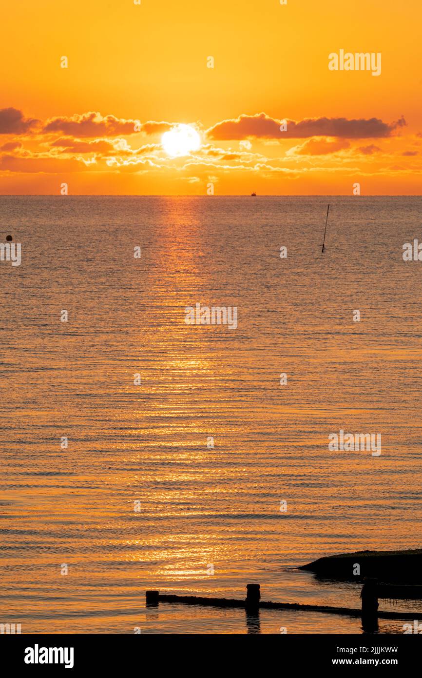 Herne Bay, Kent. 27/07/22. The sunrise over the North Sea seen from the seafront at the resort town of Herne Bay. A mostly clear sky promising sunshine and warm temperatures for the day. Credit-Malcolm Fairman, Alamy Live News. Stock Photo