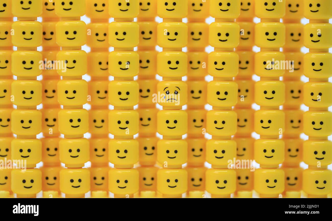 sad face inside the thousand of happy face Stock Photo