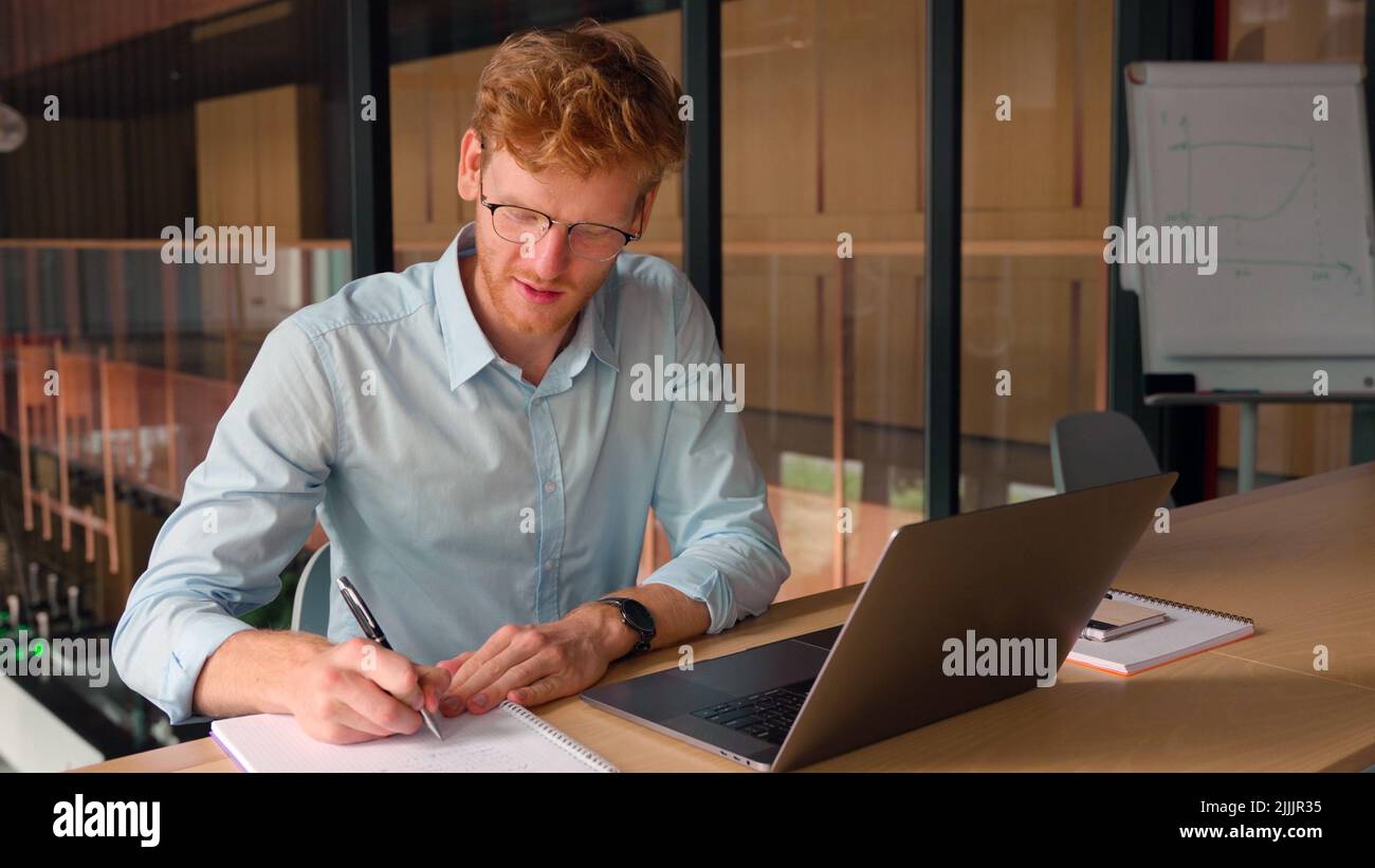 Portrait of successful confident young businessman make notes in office. Stock Photo