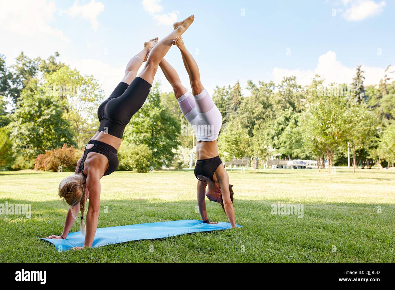 Two athletes performing duo acroyoga poses Stock Photo by Photology75