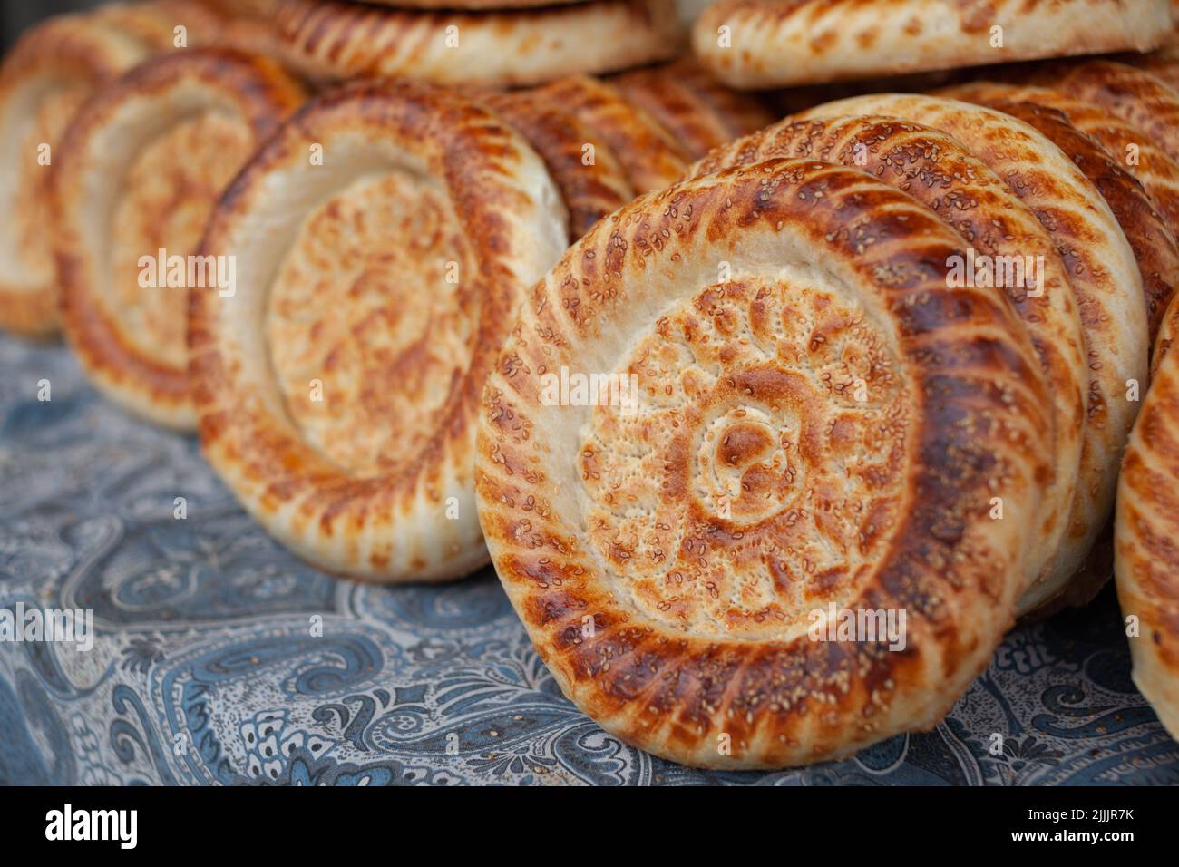 Typical traditional flatbread with crunchy crust with sesam just baked in tandoor on market