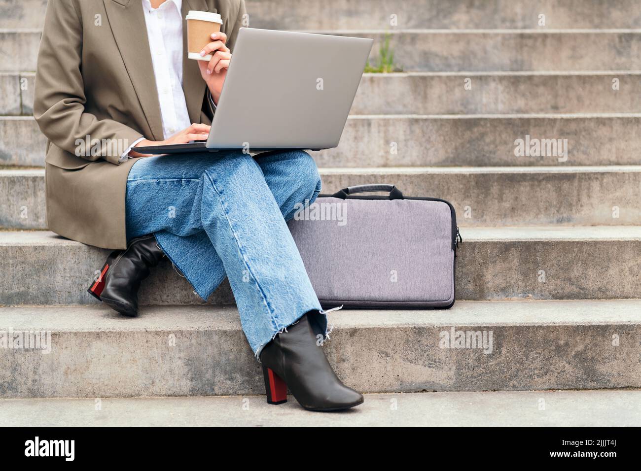 woman works outdoors with her laptop computer Stock Photo
