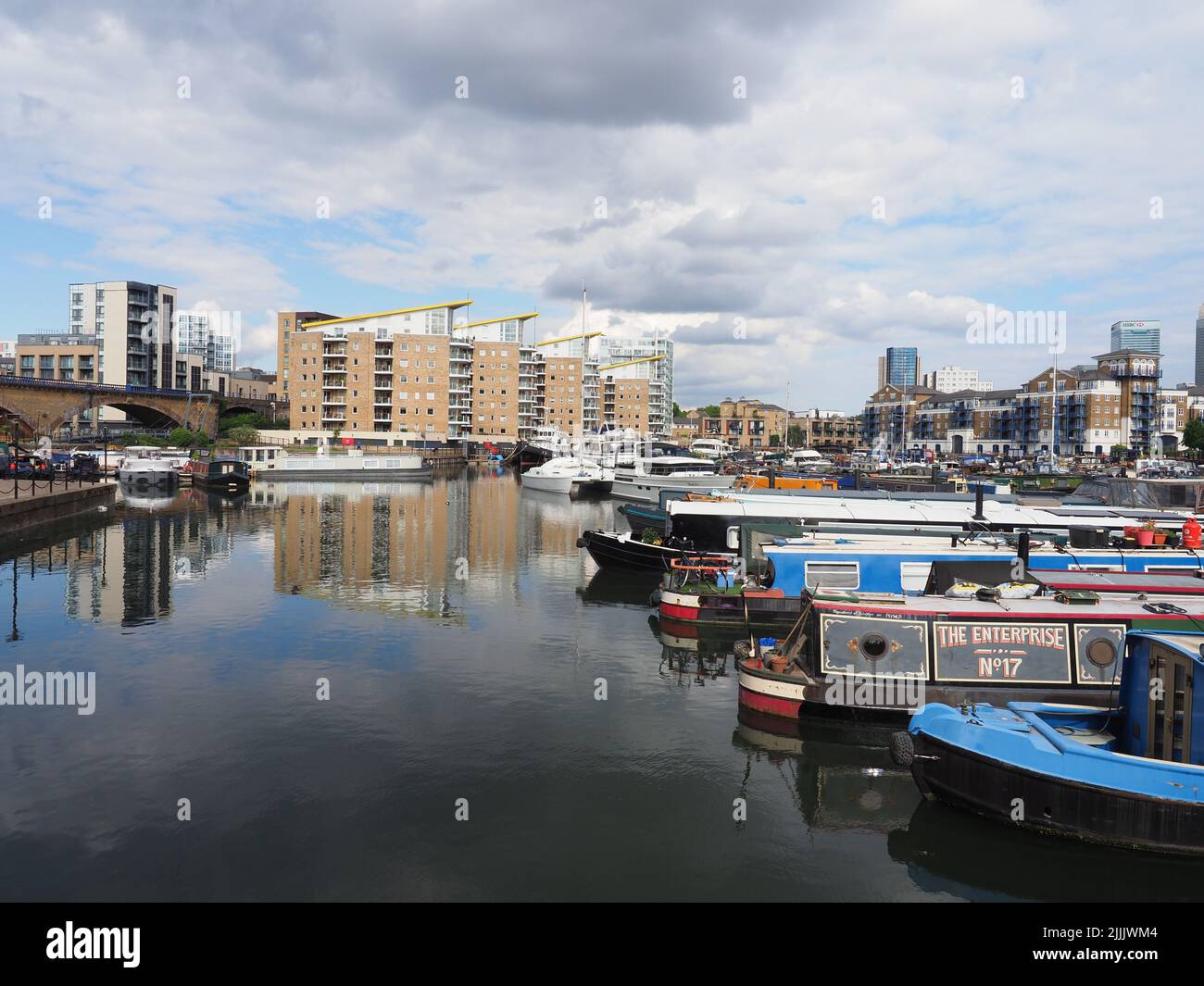 A variety of colourful houseboats at Limehouse Marina in east London with apartments in the background Stock Photo