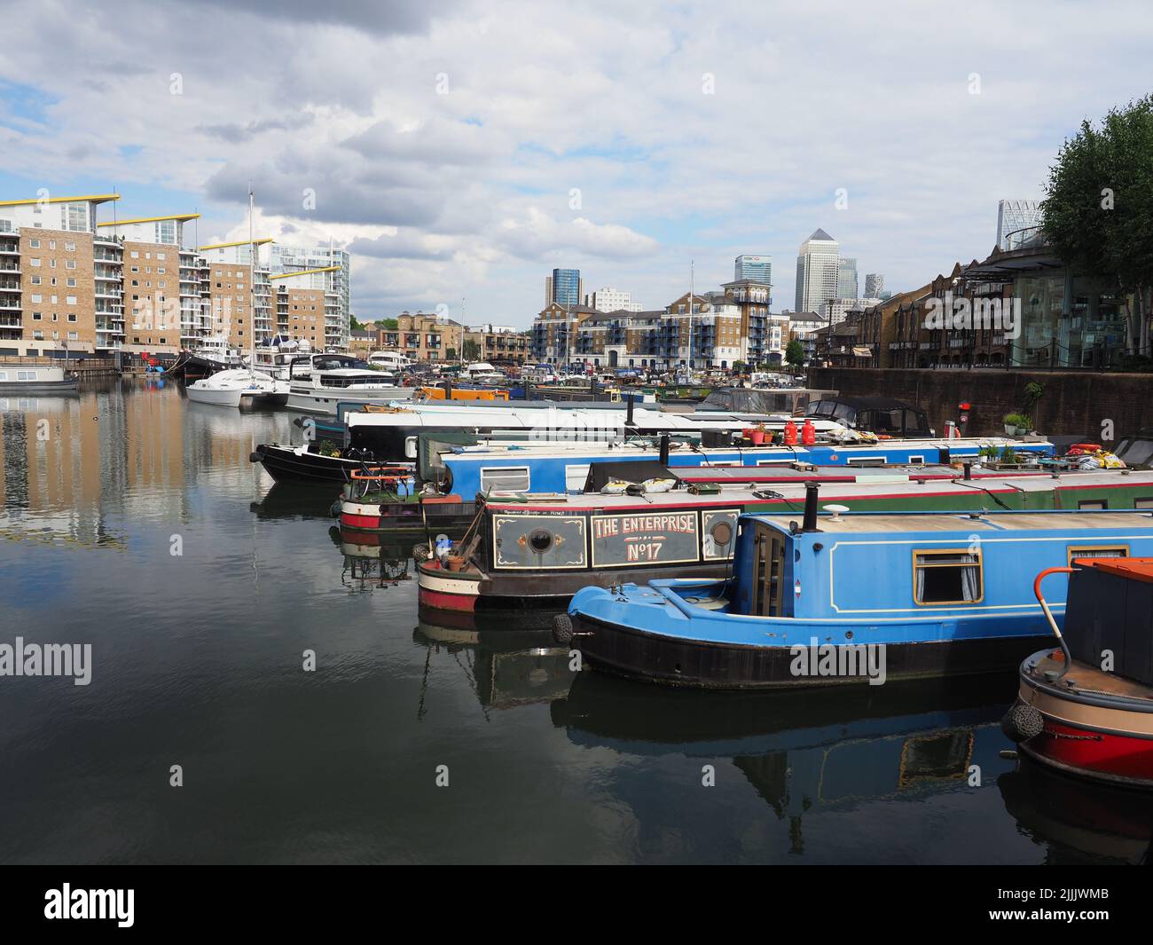 A variety of colourful houseboats at Limehouse Marina in east London with apartments in the background Stock Photo