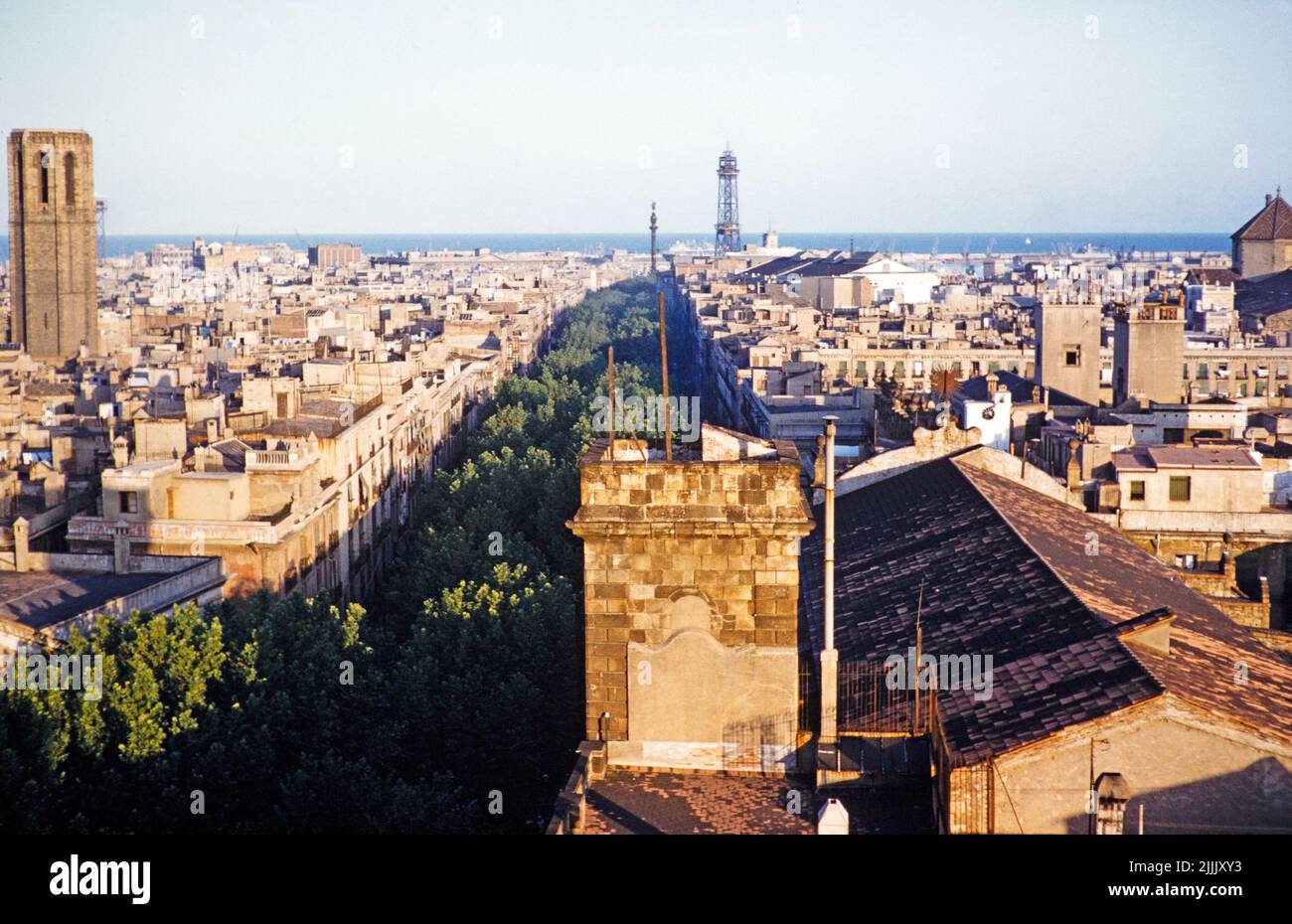 View towards the port and Torre de Jaume tower, above La Ramblas, city centre, Barcelona, Catalonia, Spain July 1958 cityscape view from what now is Hotel 1898 Stock Photo