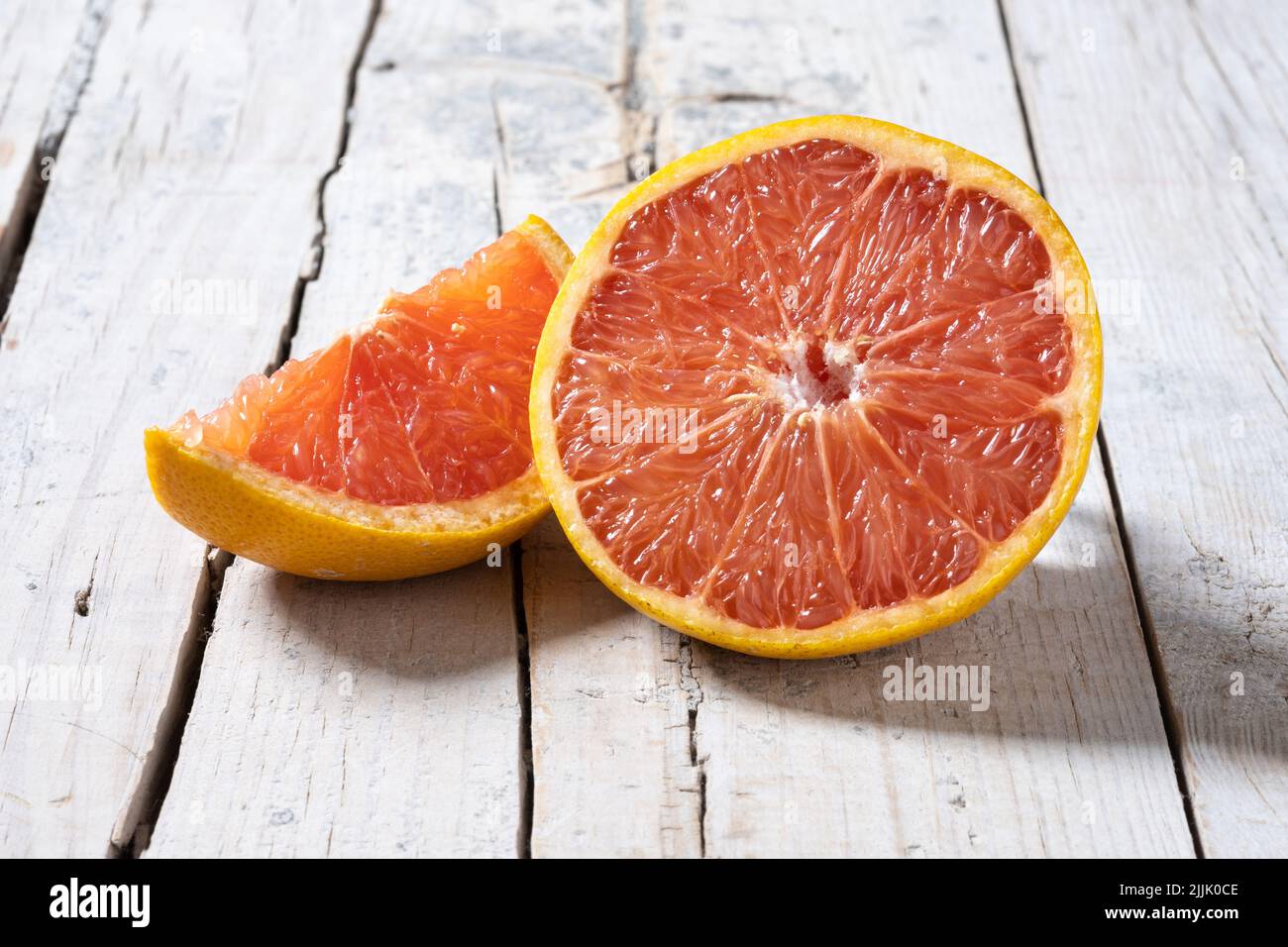 Fresh grapefruit slices on wooden table Stock Photo