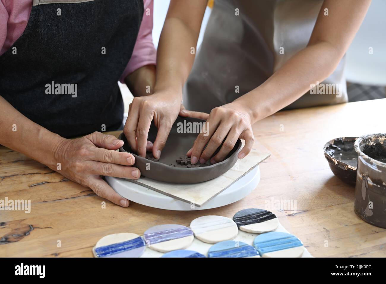 Two women are creating handicraft crockery in ceramics studio. Activity
