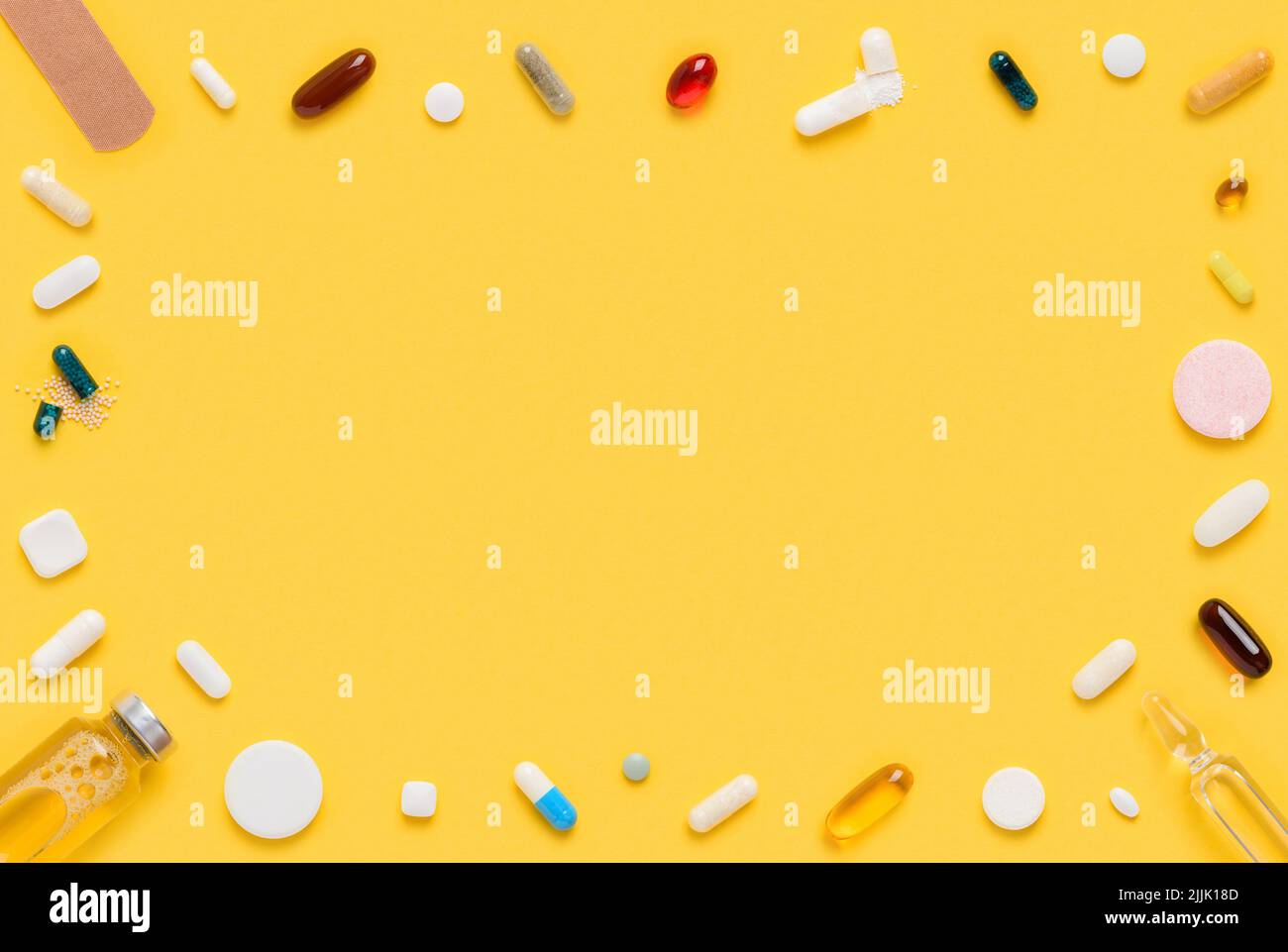 Medical drugs tablets and pills assortment frame border on yellow background top view flat lay Stock Photo