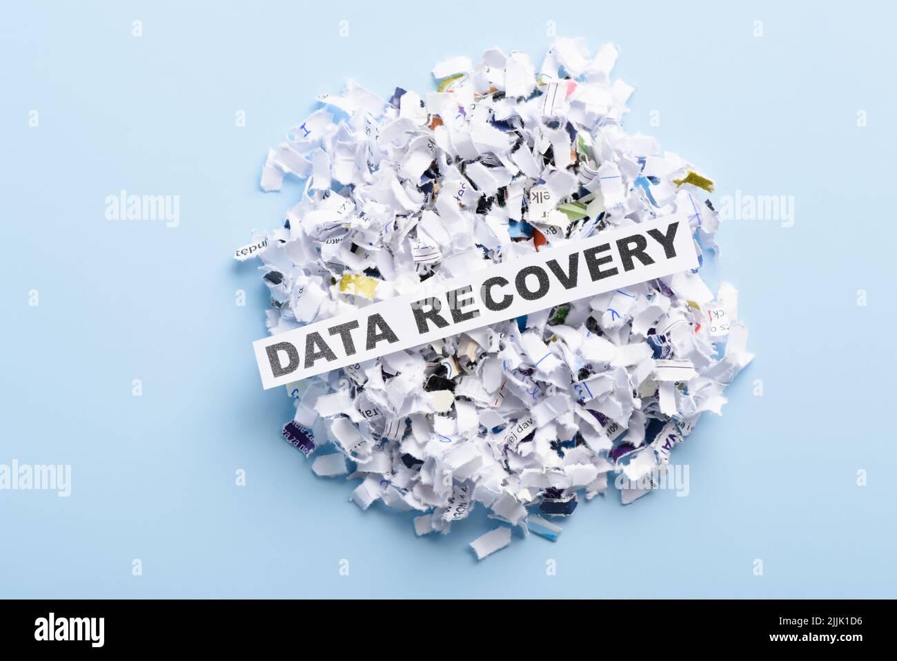Words Data recovery on top of heap of cross shredded paper concept top view Stock Photo