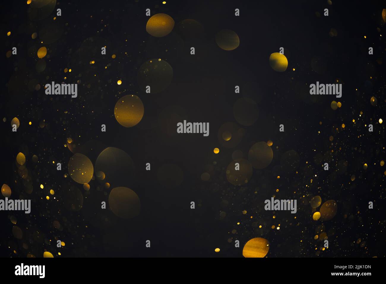 Gold glitter bokeh shiny dust particles lights abstract dark background Stock Photo