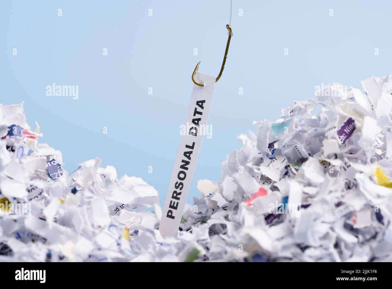 Word Personal data hooked on fishing hook pulled from pile of shredded documents on blue background Stock Photo