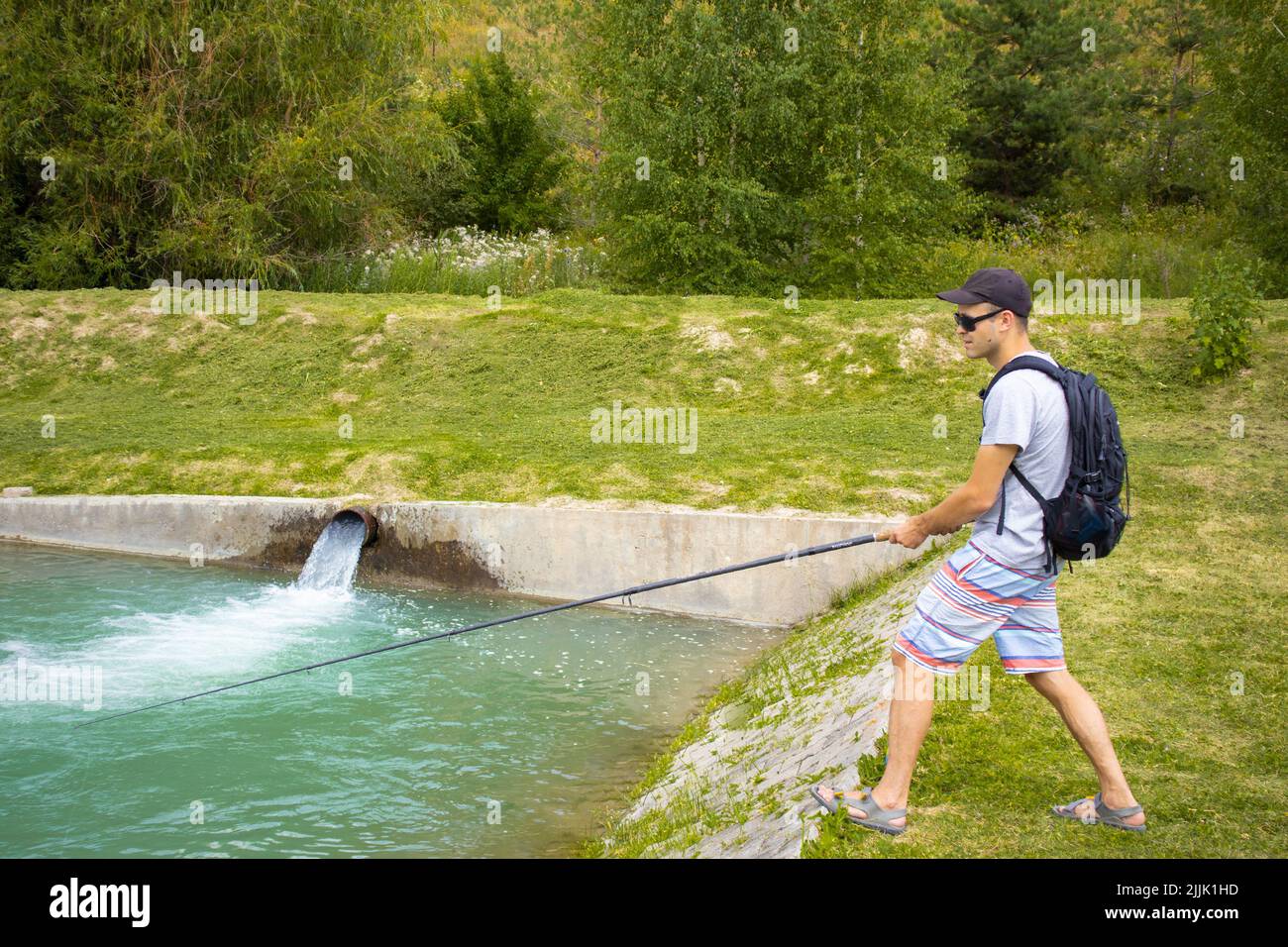 fishing on a trout farm. a guy is fishing on a trout farm Stock Photo