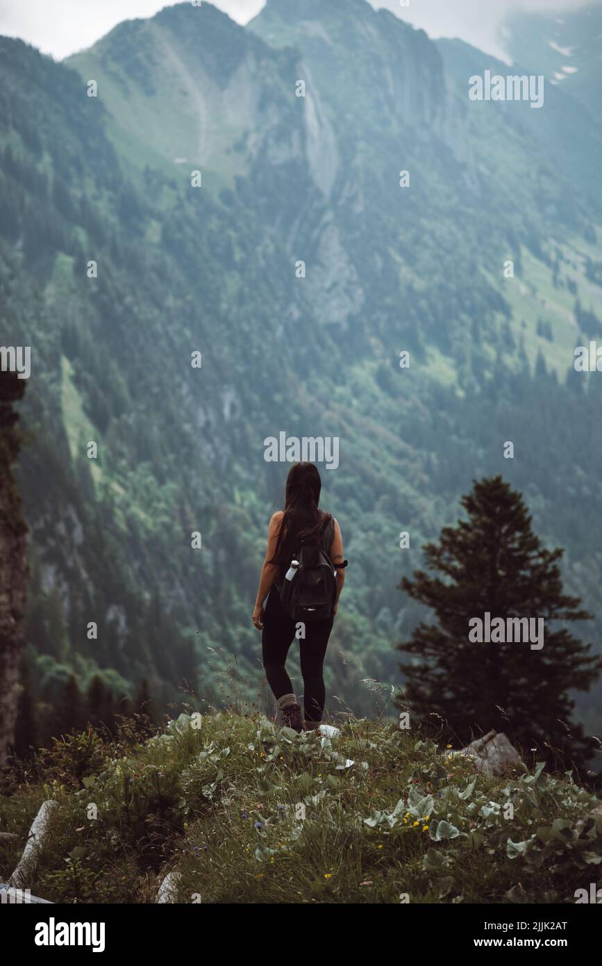 A vertical shot of a woman hiking in the Alpstein, Appenzell Alps in Switzerland Stock Photo