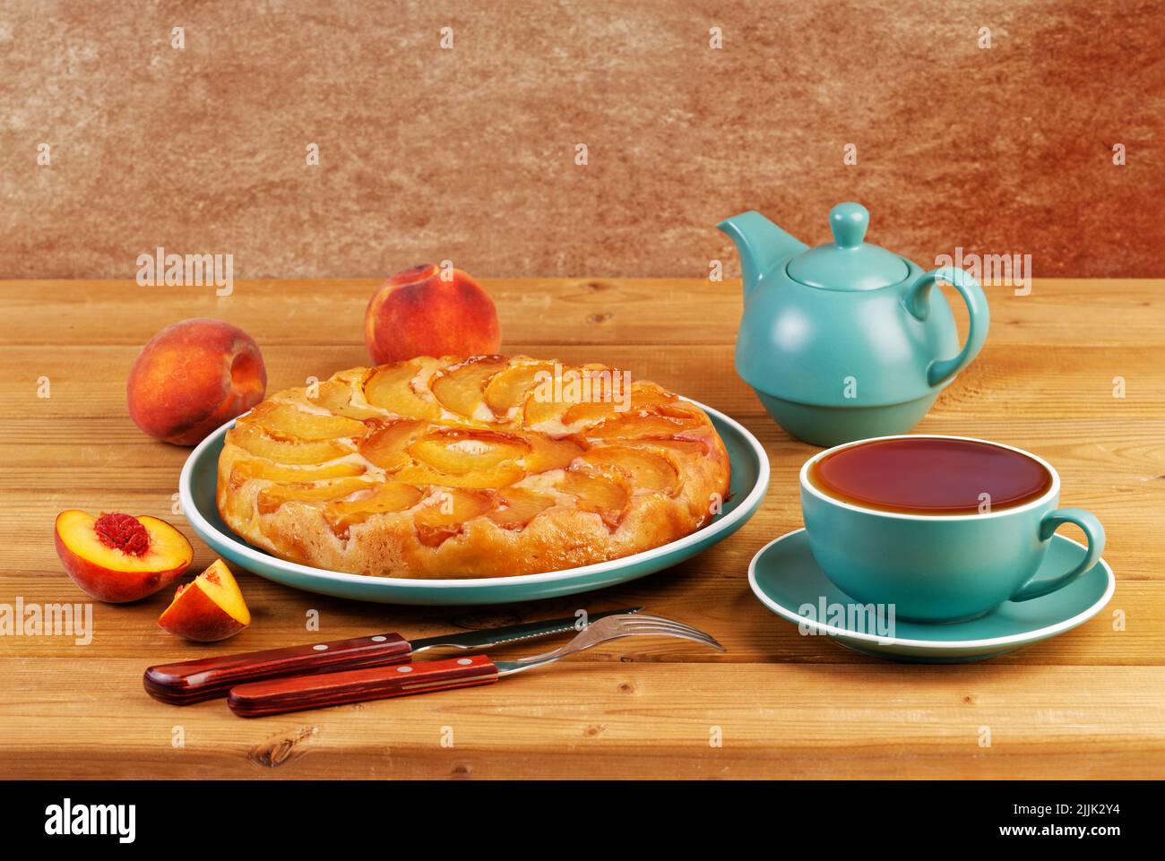 Homemade pie with peaches and cup of tea on wooden table. Copyspace. Stock Photo