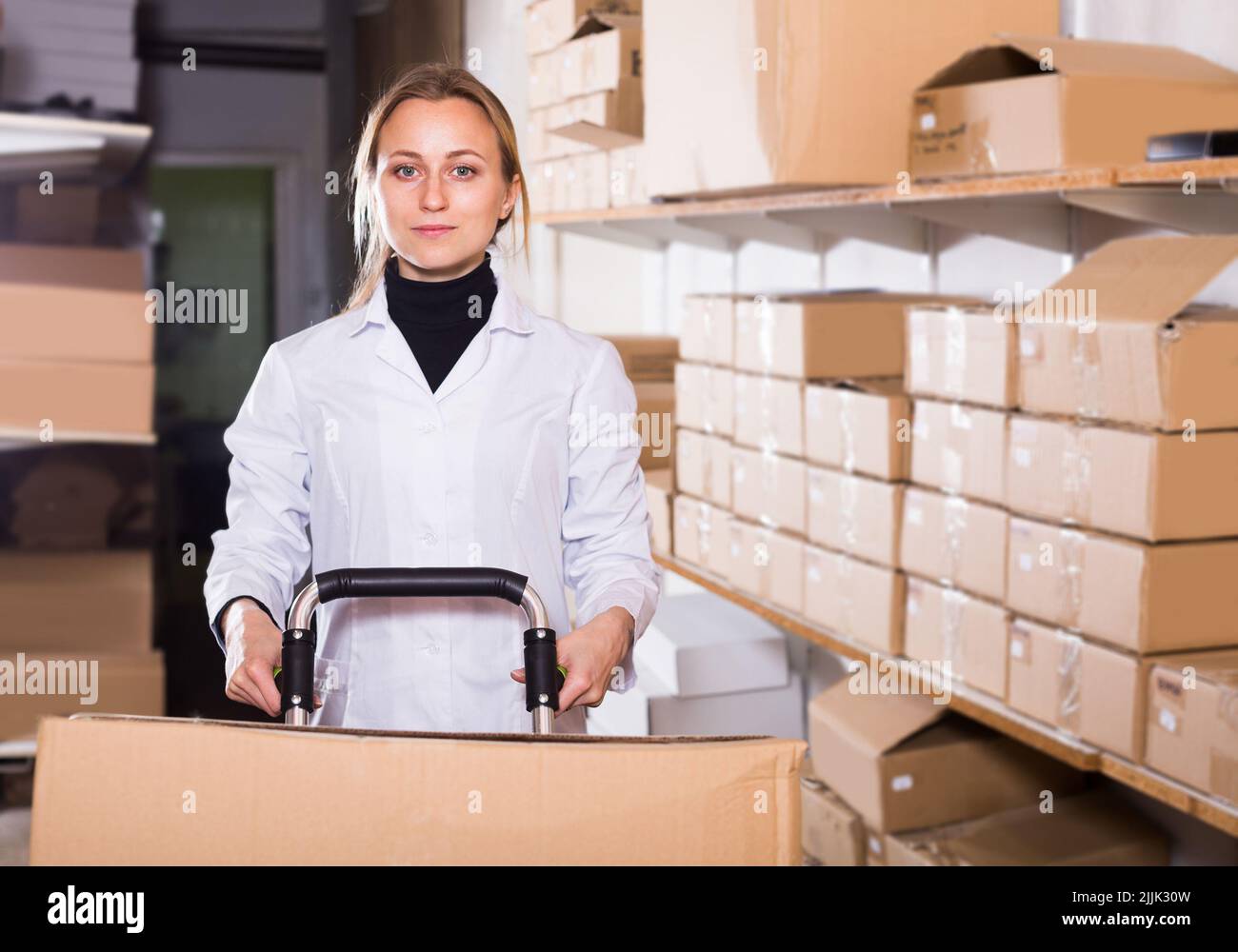 Woman worker standing with cart in production workshop Stock Photo