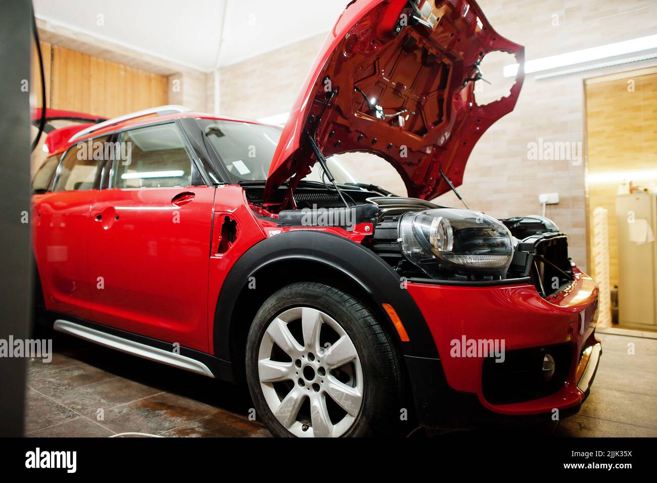 Car service red car body at the detailing vehicle Car