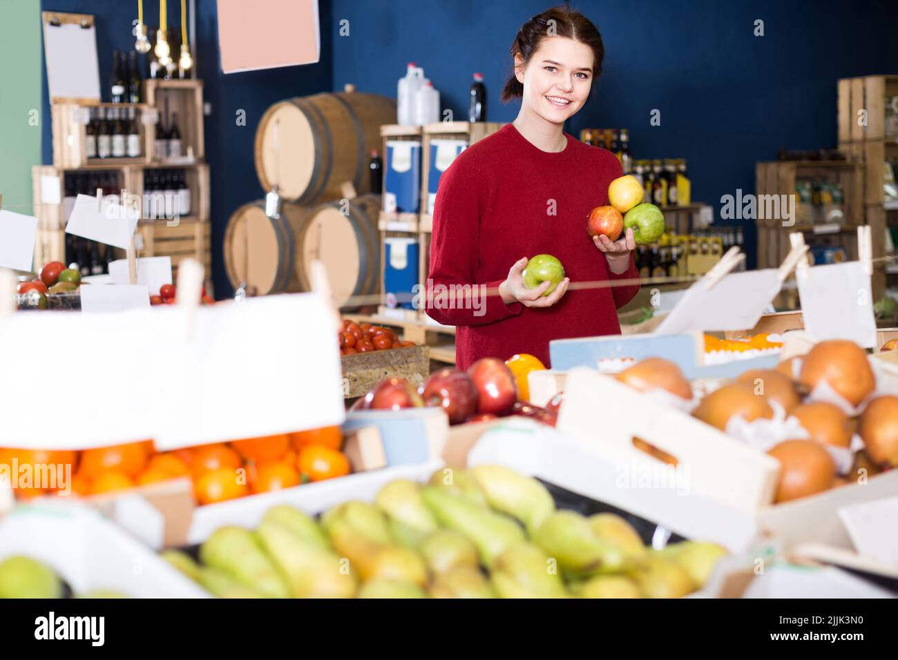 Portrait of young customer selecting apple in grocery Stock Photo