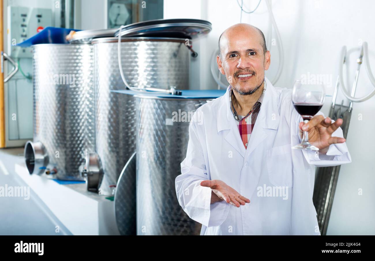 Winemaker examining sample of wine Stock Photo