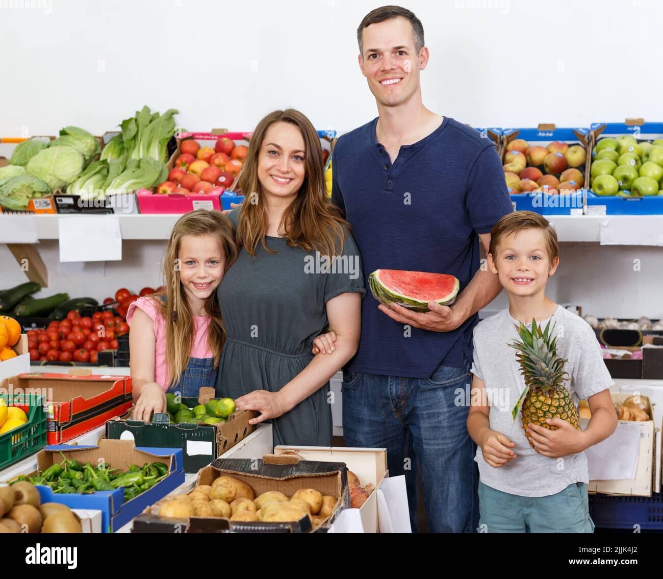 spouses with children near shelves with fruits Stock Photo