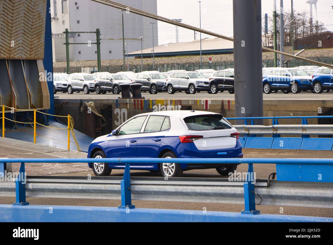 A white and blue Skoda standing near car loading container Stock Photo