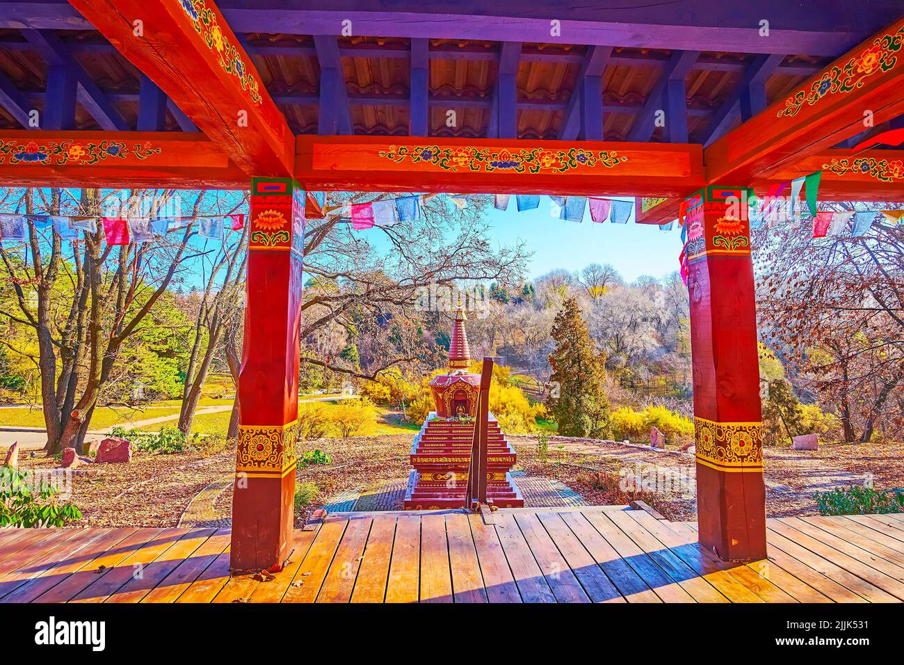 The carved stone Chorten, seen behind the timber pillars of Gazebo for