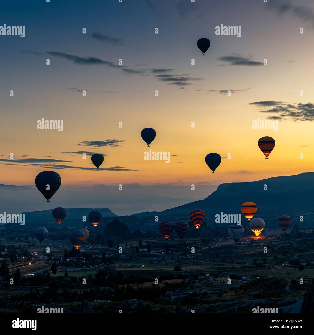 GOREME/TURKEY - June 29, 2022: hot air balloons fly over the city of goreme at sunrise. Turkey. Stock Photo