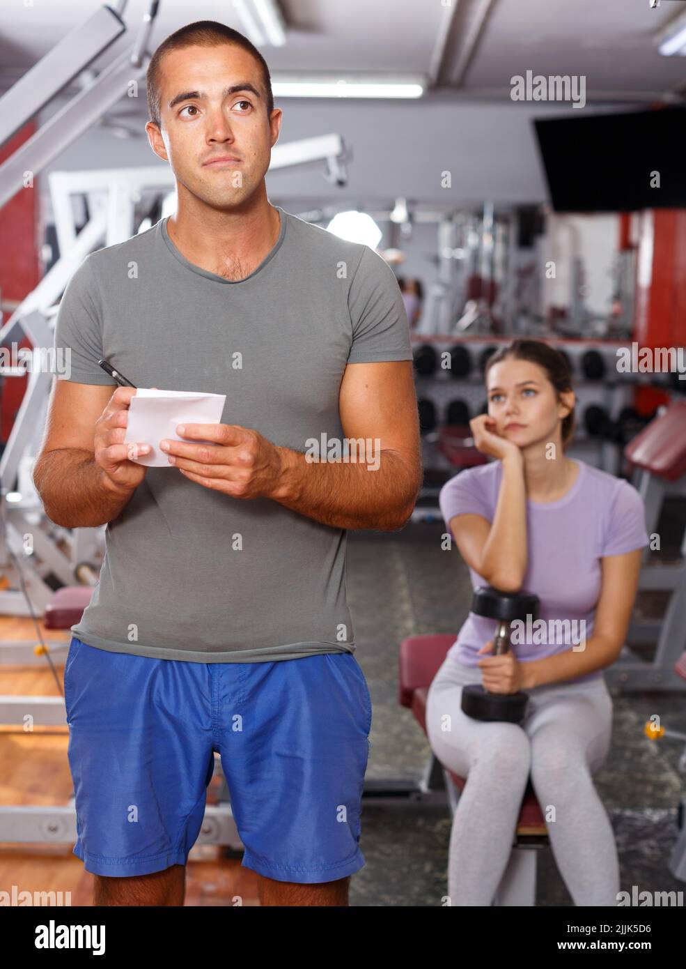 Trainer discussing workout plan with woman Stock Photo - Alamy