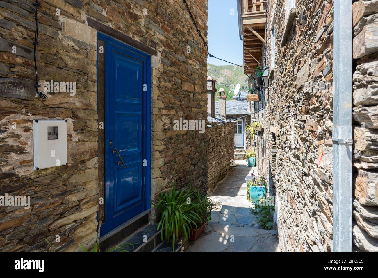 A closeup of a blue door of a house and a narrow street in the center of Piodao village, Portugal Stock Photo