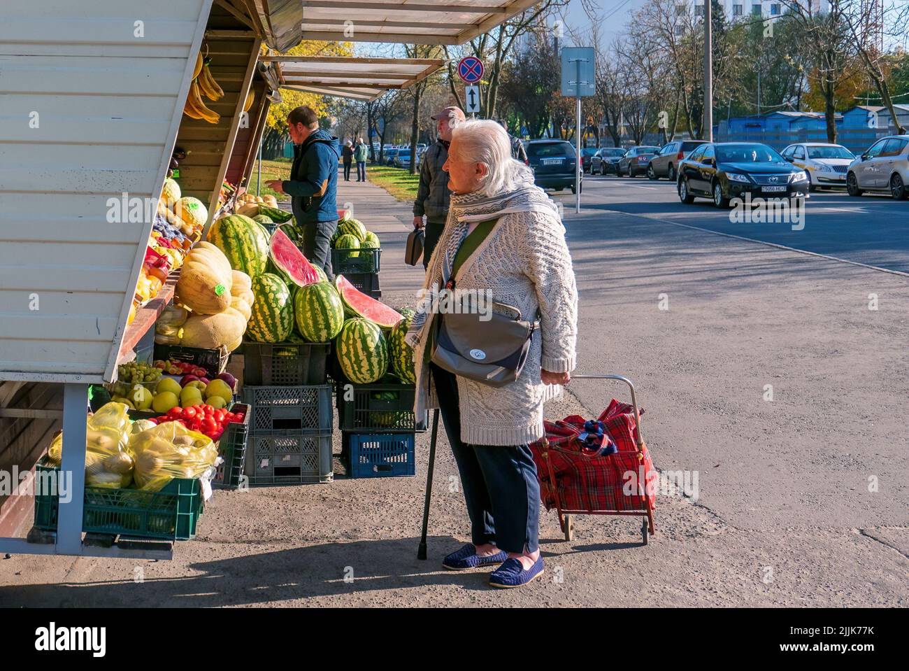 Minsk, Belarus - October 09, 2018: A very old woman looks at the fruit stalls. The concept of financial difficulties in old age Stock Photo