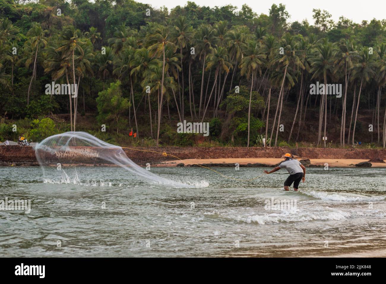 A local Indian fisherman throwing the net into the ocean in the village of Betul, Salcete, Goa, India Stock Photo