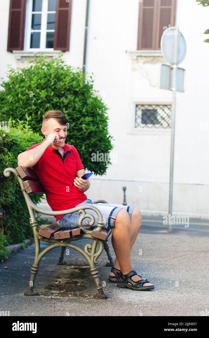 Young handsome man, tourist walking in summer park, old city. Phone call. Technology. Social media. Vacation. Working online Stock Photo