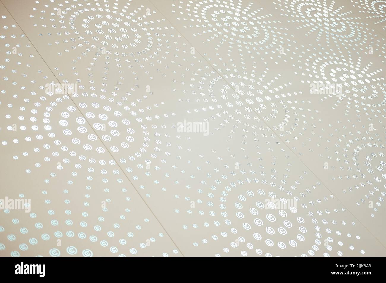A closeup shot of a white surface with a spotted light pattern Stock Photo