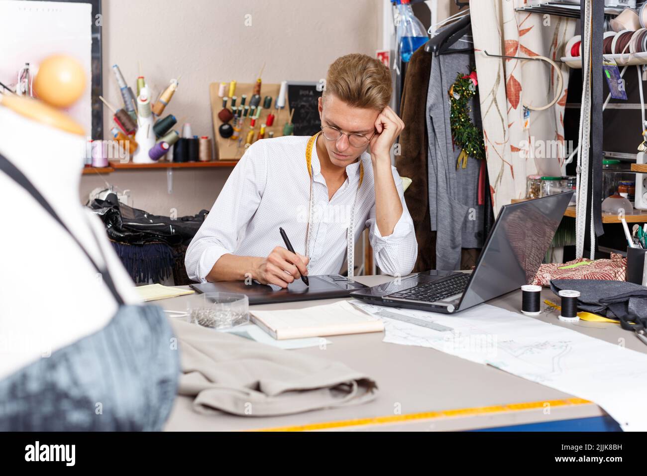 Tailor creating pattern using laptop Stock Photo