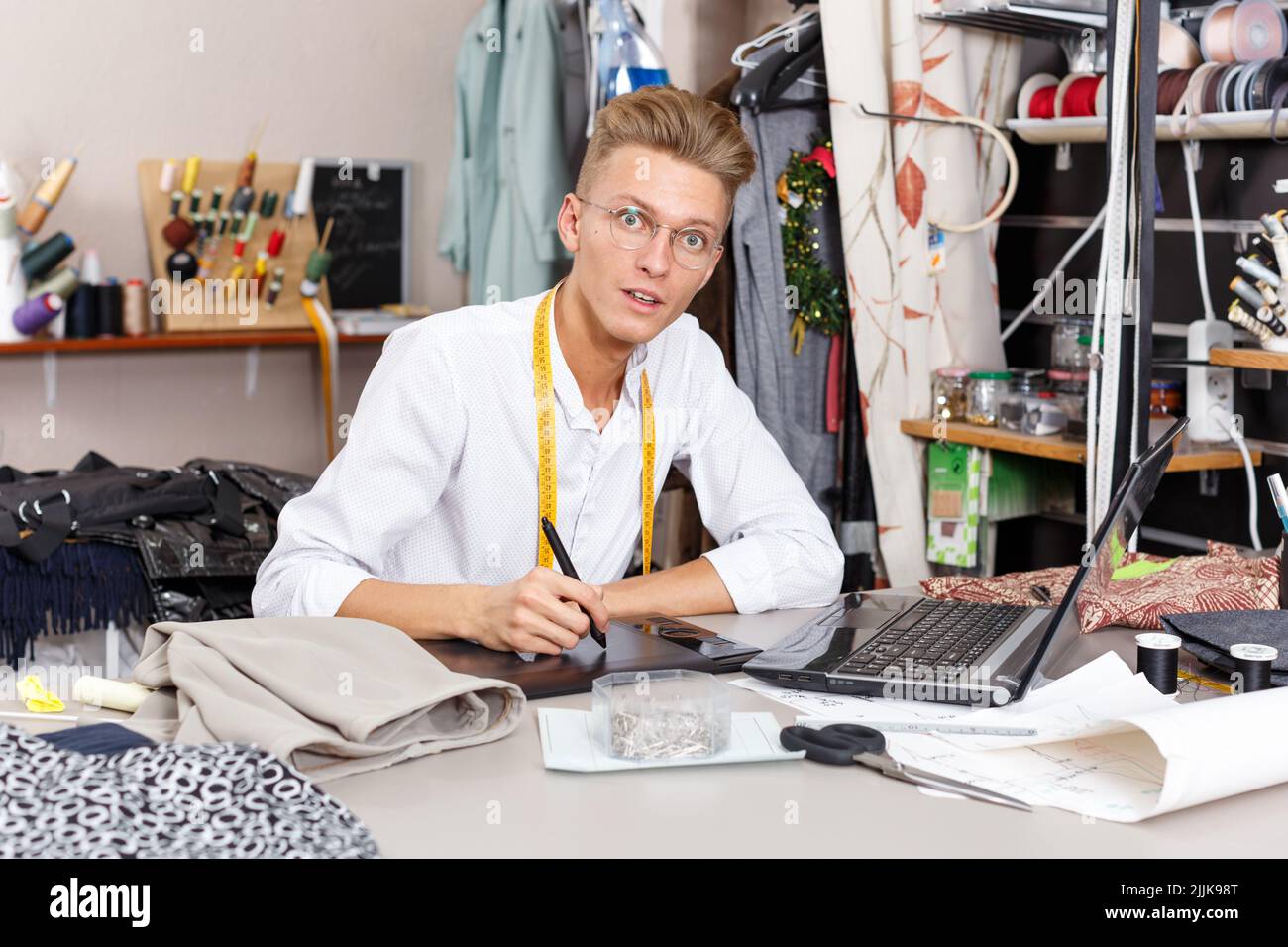 Tailor creating pattern using laptop Stock Photo